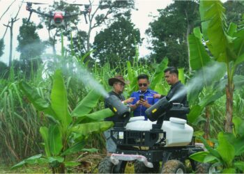MOHD. Farid Daud (tengah) menunjukkan penggunaan dron bagi tujuan semburan pokok pisang pada Program Anak Muda Menerajui Ladang Integrasi Moden di Labu Hilir, Seremban hari ini.-UTUSAN/MOHD. SHAHJEHAN MAAMIN.