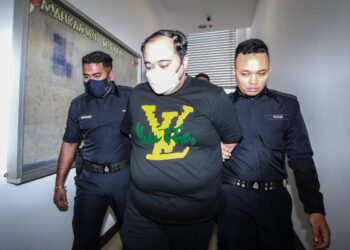 Khairul Khuzaini dibawa anggota polis selepas prosiding pertuduhan pengubahan wang haram di Mahkamah Sesyen Shah Alam. - UTUSAN/AFIQ RAZALI