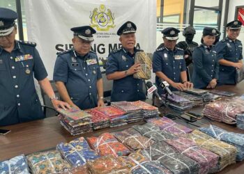 MOHD. Nasir Deraman (tiga kiri) menunjukkan kain sarung yang dirampas oleh JKDM Sabah semasa sidang akhbar di Kota Kinabalu, hari ini.