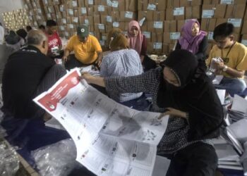 PETUGAS melipat kertas undi Parlimen Pemilu 2024 di sebuah gudang di Medan, Sumatera Utara, Indonesia.-AGENSI