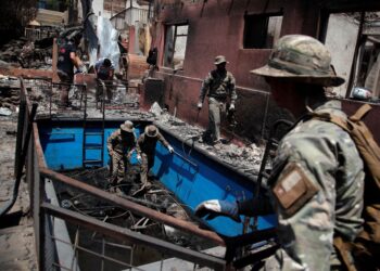 TENTERA laut Chile membantu membersihkan rumah yang musnah akibat kebakaran hutan di Villa Independencia, wilayah Valparaiso di Chile. - AFP
