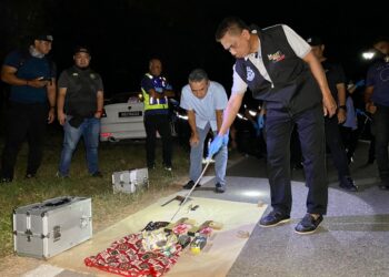 FISOL Salleh menunjukkan dua pucuk pistol dan 240 butir peluru yang ditemui dalam kereta suspek yang maut dalam kejadian berbalas tembakan di Jalan Bukit Kechil, Napoh di Jitra. -UTUSAN/SHAHIR NOORDIN