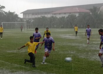 Hujan lebat  mewarnai perlawanan antara Kudus FC dan Solid  FC merebut Piala Tok Mat di Padang Sekolah Kebangsaan ( SK ) Sri Benut, di Pontian, Johor, petang semalam. KOSMO/UTUSAN/MUHAMMAD ZIKRI