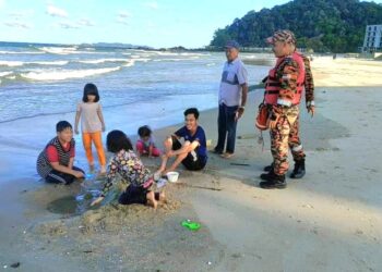 ANGGOTA bomba memberi nasihat kepada pengunjung ketika membuat pemantauan di  Pantai Pandak, Chendering, Kuala Terengganu, semalam.