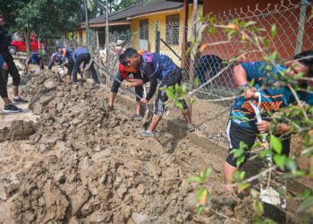 SEBAHAGIAN sukarelawan yang menyertai gotong–royong membersih lumpur di SK Pasir Raja, Hulu Dungun, Dungun, hari ini. - UTUSAN/PUQTRA HAIRRY ROSLI