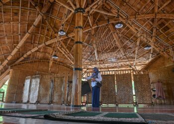 Siti Nuratirah Che Mohd. Nasir melihat keunikan Surau Buluh yang baru siap dibina di Kampung Banggol Tiang Kulat, Kuala Nerus, Terengganu. - UTUSAN/PUQTRA HAIRRY ROSLI