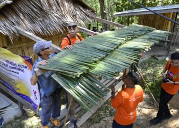 AAKTIVITI menganyam atap menggunakan daun kelapa.