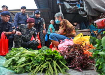 RAZARUDIN Husin bertanyakan sesuatu kepada seorang peniaga sayur ketika melakukan lawatan ke Pasar Pagi Pandamaran di Klang, Selangor, semalam. – UTUSAN/AFIQ RAZALI