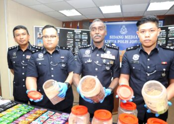 M. KUMAR (dua dari kanan) menunjukkan serbuk ekstasi berwarna coklat yang dirampas dalam sidang media di IPK Johor, Johor Bahru.