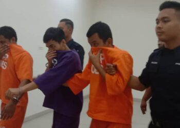 MAHATHIR Hamzi (kiri), Muhammad Nazry (tengah) dan Muhamad Amirul (kanan) dibawa keluar dari Mahkamah Majistret Muar selepas didakwa mengedar syabu seberat 82.86 kg, bulan lalu.
