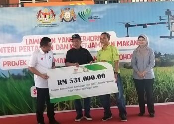 MOHAMAD Sabu (dua dari kiri) menyampaikan replika cek Program Bantuan Khas Tunai kepada pesawah sempena Lawatan ke Sawah Ring, Tangkak.