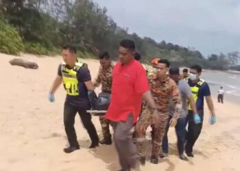 ANGGOTA pasukan penyelamat mengusung mayat Guo Lei yang lemas di Pantai Tanjung Jara, Dungun, hari ini. - UTUSAN/NIK NUR IZZATUL HAZWANI NIK ADNAN