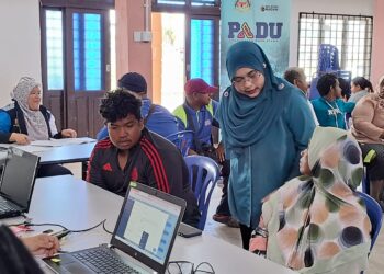 MARLINI Sahul Hamid (dua, kanan) memberi penerangan kepada salah seorang penduduk Orang Asli Sungai Pergam mengenai sistem Padu, hari ini. - UTUSAN/NIK NUR IZZATUL HAZWANI NIK ADNAN