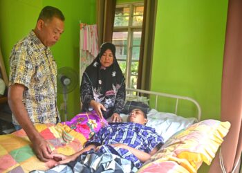WAN Murni Wan Ngah (tengah) bersama Rosol Wahid (kanan) melihat keadaan anaknya, Muhammad Amirul Nazmi Sam di rumahnya di Kampung Jaba, Bukit Apit, Hulu Terengganu, hari ini.