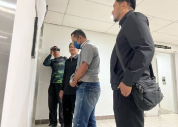MOHD. Saiful Nizam (dua, kanan) yang dijatuhkan hukumam penjara dua tahun atas kesalahan salah guna kuasa dibawa keluar dari  Mahkamah Sesyen Kuala Terengganu, hari ini. - UTUSAN/TENGKU DANISH BAHRI TENGKU YUSOFF