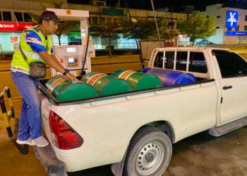 PEGAWAI Penguatkuasa KPDN Cawangan Temerloh memeriksa minyak diesel yang diisi ke dalam tong tanpa permit khas di sebuah stesen minyak di Temerloh, Pahang.