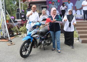 WAN ROSDY Wan Ismail (kiri) menyampaikan hadiah cabutan bertuah sebuah motosikal kepada pemenang Norlaili Putih sempena Moh Karnival Makmur 2024 Daerah Maran di Chenor, Maran, Pahang. - UTUSAN/SALEHUDIN MAT RASAD