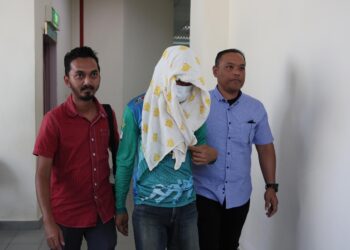 MOHD. Affandi Awang (tengah) dibawa keluar dari Mahkamah Tinggi Syariah Terengganu di Kuala Terengganu, hari ini..- UTUSAN/PUQTRA HAIRRY ROSLI