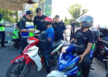 LOKMAN Jamaan memeriksa dokumen seorang penunggang motosikal pada
Ops Khas Musim Perayaan Tahun Baharu Cina di Jambatan Sultan Mahmud, Kuala Terengganu hari ini. - UTUSAN/TENGKU DANISH BAHRI TENGKU YUSOFF