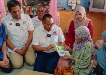 PANDAK Ahmad (tiga dari kiri) menyampaikan bantuan kepada Roalah Midi pada Program Ziarah Kasih ADUN Kota Iskandar di Kampung Pekajang, Iskandar Puteri.