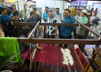 RAZALI Idris (tengah) melawat gerai pameran selepas majlis perasmian Karnival Beautiful Terengganu di Kuala Terengganu, malam tadi. - UTUSAN/PUQTRA HAIRRY ROSLI