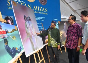 SULAIMAN  Sulong (kiri) melihat antara hasil karya yang dirakamkan jurugambar di dasar laut perairan Terengganu ketika merasmikan Sultan Mizan Photography Awards 2024 di Kuala Terengganu ,hari ini. - UTUSAN/KAMALIZA KAMARUDDIN