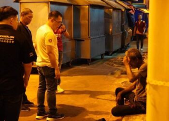 LING TIAN SOON (baju putih) bertanya soalan kepada seorang gelandangan di bandar raya Johor Bahru.