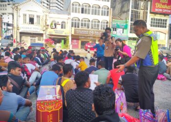 MOHAMAD Hatta Che Din (kanan) memeriksa warga asing dalam operasi bersepadu yang diadakan di pusat bandar Seremban petang tadi.-UTUSAN/BADRUL HAFIZAN MAT ISA