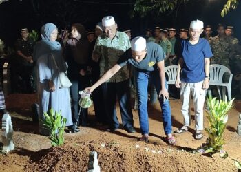 MUHAMMAD Syukri Din sedang menyiram air mawar di atas pusara sahabatnya, Allahyarham Mohd Hafiz Haris di Tanah Perkuburan Islam Masjid Al Wajdi, Bukit Selambau di Sungai Petani.