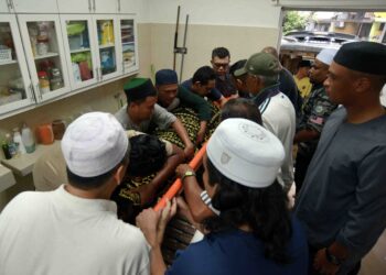 AHLI keluarga menguruskan jenazah Allahyarham Khalid Ali  di Kuala Lumpur, semalam. - UTUSAN/SYAKIR RADIN