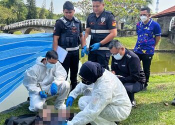 POLIS memeriksa mayat yang dijumpai terapung di Taman Tasik Shah Alam, hari ini.