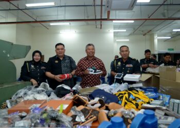 Zakaria Shaaban (tengah) bersama  Pengarah Kementerian Perdagangan Dalam Negeri dan Ehwal Pengguna Wilayah Persekutuan Kuala Lumpur, Ariffin Samsudin ketika menunjukkan barangan rampasan pada Program Pelupusan Mega KPDN WPKL  di Stor Eksibit Segambut, Kuala Lumpur hari ini. - UTUSAN/SYAKIR RADIN