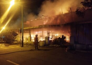 ANGGOTA bomba memadam kebakaran sebuah kedai runcit dua tingkat di Kampung Baru, Ayer Tawar semalam. - UTUSAN/IHSAN JBPM PERAK