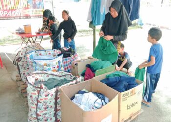 PENGUNJUNG memilih barangan persekolahan yang diperlukan di Pusat Pembelajaran dan Pengasingan Barang Kitar Semula (3R), Taman Bandar, Tanjung Malim, Perak. – UTUSAN/MEGAT LUTFI MEGAT RAHIM