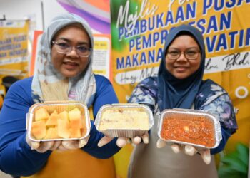 PESERTA, Nuraziah Abdul Azin (kiri) dan Wan Najiah Wan Saidin menunjukkan produk inovasi yang dihasilkan di Pusat Pemprosesan Makanan Inovatif UMT di Manir, Kuala Terengganu, hari ini. - UTUSAN/KAMALIZA KAMARUDDIN