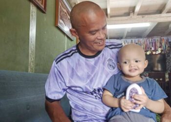 NORHATINAH Ahmad (kanan) memangku anaknya, Mohd. Khalish Arjuna ketika menerima kunjungan Pengerusi FOCCAN, Maznah Tayib di Bagan Serai kelmarin. - UTUSAN/WAT KAMAL ABAS