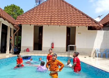 SEBAHAGIAN penghuni rumah anak yatim mandi di kolam renang sebelum berkhatan di Hotel De Cassia, Kampar. - UTUSAN