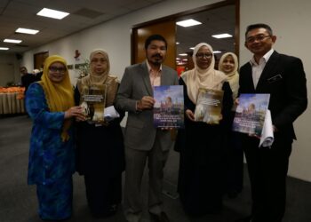 MOHD. Uzir menunjukkan Buku Kajian Diaspora Malaysia di Brunei pada majlis pelancaran kajian tersebut dan juga laporan Kajian Penggajian Pelakon Kanak-Kanak dan Orang Muda Dalam Filem dan Drama di Putrajaya, semalam. - UTUSAN/ FAISOL MUSTAFA