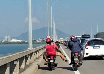 TANGKAP layar yang diambil daripada satu rakaman video menunjukkan seorang pembonceng wanita cuba melempar objek dipercayai pasir selain cuba menendang penunggang motosikal lain di Jambatan Pulau Pinang, semalam.