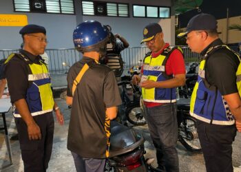 ZULKIFLY (dua dari kanan) memeriksa motosikal yang ditunggangi seorang lelaki OKU di susur masuk lorong motosikal Jambatan Pulau Pinang, Pulau Pinang.UTUSAN / SITI NUR MAS ERAH AMRAN