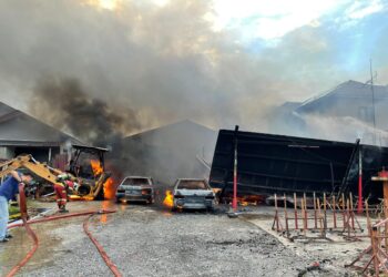 ANGGOTA bomba memadamkan kebakaran yang berlaku di Kampung Baru Nilai, Nilai, Seremban, petang tadi.-UTUSAN/NUR SHARIEZA ISMAIL.