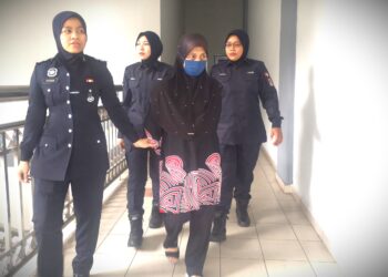 NORSHAM Ismail dibawa anggota polis bagi didakwa di Mahkamah Sesyen Seremban hari ini atas pertuduhan menganiaya ke atas seorang bayi perempuan berusia 10 bulan di sebuah taska di Desa Cempaka, Nilai, Seremban pada 5 Februari lalu.-UTUSAN/NUR SHARIEZA ISMAIL.