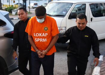 SEORANG jurutera (tengah) yang didakwa atas pertuduhan meminta dan menerima suapan berjumlah RM13,000 diiringi oleh dua anggota SPRM ketika tiba di Mahkamah Majistret George Town, Pulau Pinang.-UTUSAN / IQBAL HAMDAN