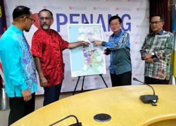 CHOW Kon Yeow (dua dari kanan) menunjukkan pelan pembangunan taman-taman perindustrian milik Perbadanan Pembangunan Pulau Pinang (PDC) di Pulau Pinang.