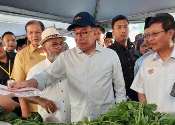 ANWAR Ibrahim (tengah) menyerahkan risalah harga barang kepada peniaga sempena Program Jualan Termurah Madani di Lembah Makanan Bandar Perda, Bukit Mertajam, Pulau Pinang