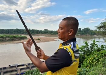 HAMIDI Yaakob menunjukkan keris panjang yang ditemukan tersangkut di jaring miliknya di Sungai Pahang di Kampung Kelola, Pulau Tawar di Jerantut, Pahang. - UTUSAN/SALEHUDIN MAT RASAD