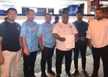 MOHAMAD Afif Anuar (tiga dari kanan) menunjukkan laporan polis AMK Negeri Sembilan terhadap Dd Chronicle di Balai Polis Seremban 2 Seremban malam ini.-UTUSAN/NAZARUDIN SHAHARI.