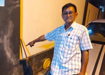 BAPA mangsa menunjukkan batang pencuci lantai yang turut digunakan untuk memukul anaknya dalam kejadian pergaduhan di Dengkil Selangor.