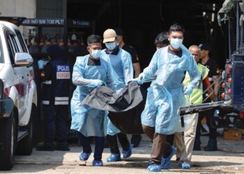 ANGGOTA polis membawa keluar mayat mangsa yang terkorban dalam kejadian letupan gas di kilang kimpalan di Taman Perindustrian Puchong, Subang Jaya, Selangor, semalam. - UTUSAN/SHIDDIEQIIN ZON