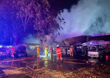 Anggota bomba memadam kebakaran kereta dan motosikal di kawasan tempat letak kenderaan dua bengkel di Taman Keladi, Sungai Petani awal pagi ini.